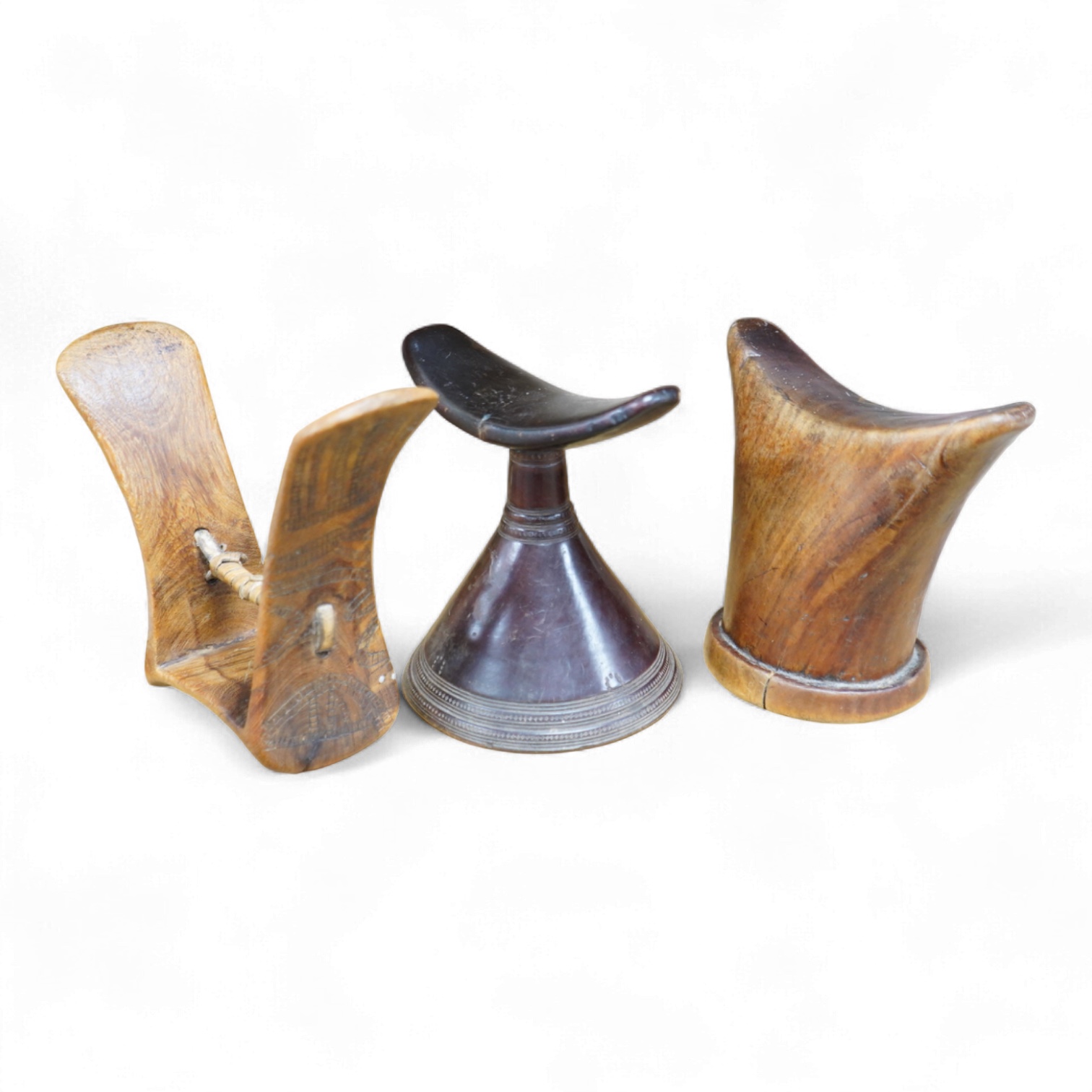 Three African wood head rests, two with carved decoration, largest 18cm high